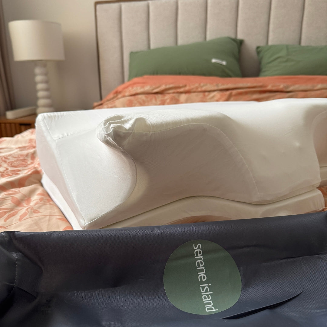Serene Island pillow plus on a bed with a visible brand label.